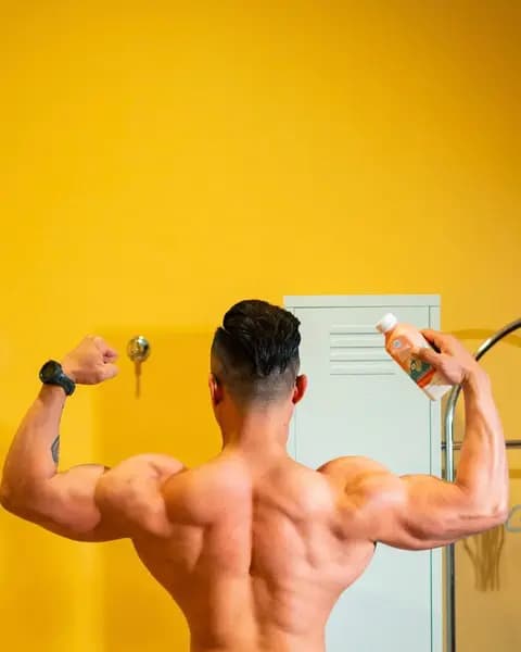 A bodybuilder flexing from behind, a C7 smoothie in a raised hand